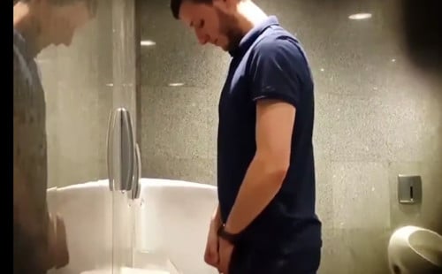 Watch him taking a piss at the urinals