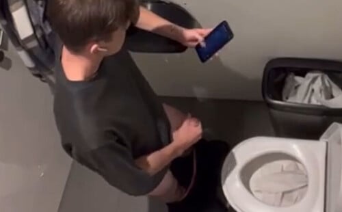Guy wanking in a public toilet