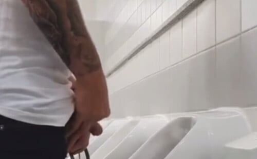 Guy with inked arm caught peeing
