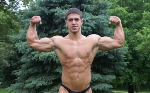 Muscled bodybuilder showing off his big bulge in small posers