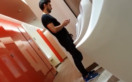 sexy guy dressed in black caught peeing at urinals