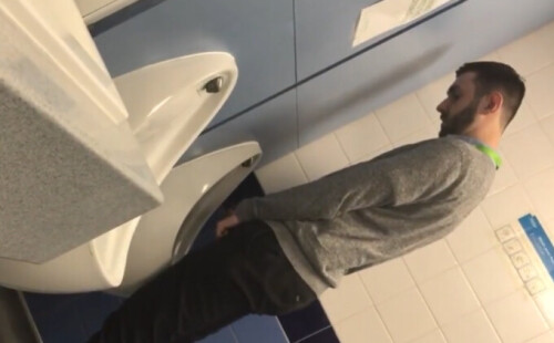 Guy peeing at airport urinals