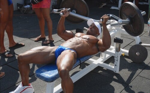 Paparazzi shots of a black bodybuilder in skimpy posers